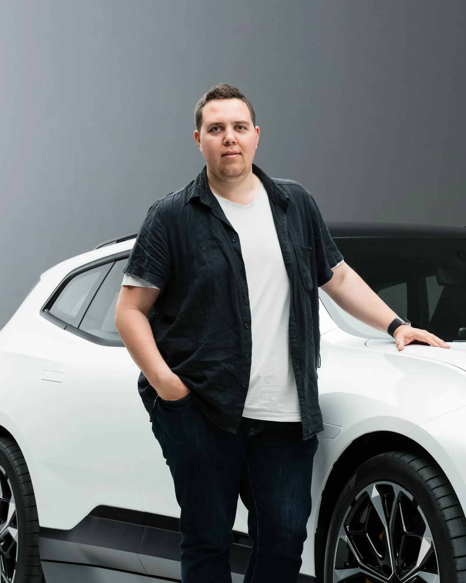 Christoffer Gullin i studio, med handen på huven på en vit bil